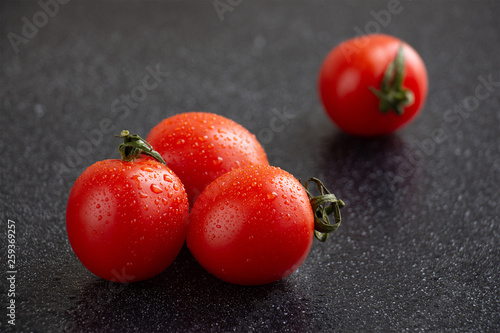 Close-up of cherry tomatoes with water drops with black background