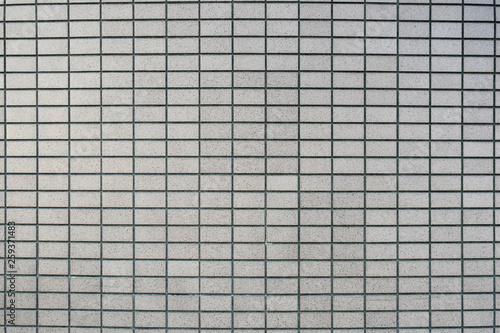 Grey tiles wall texture installation in straight or stack bond. Close-up.