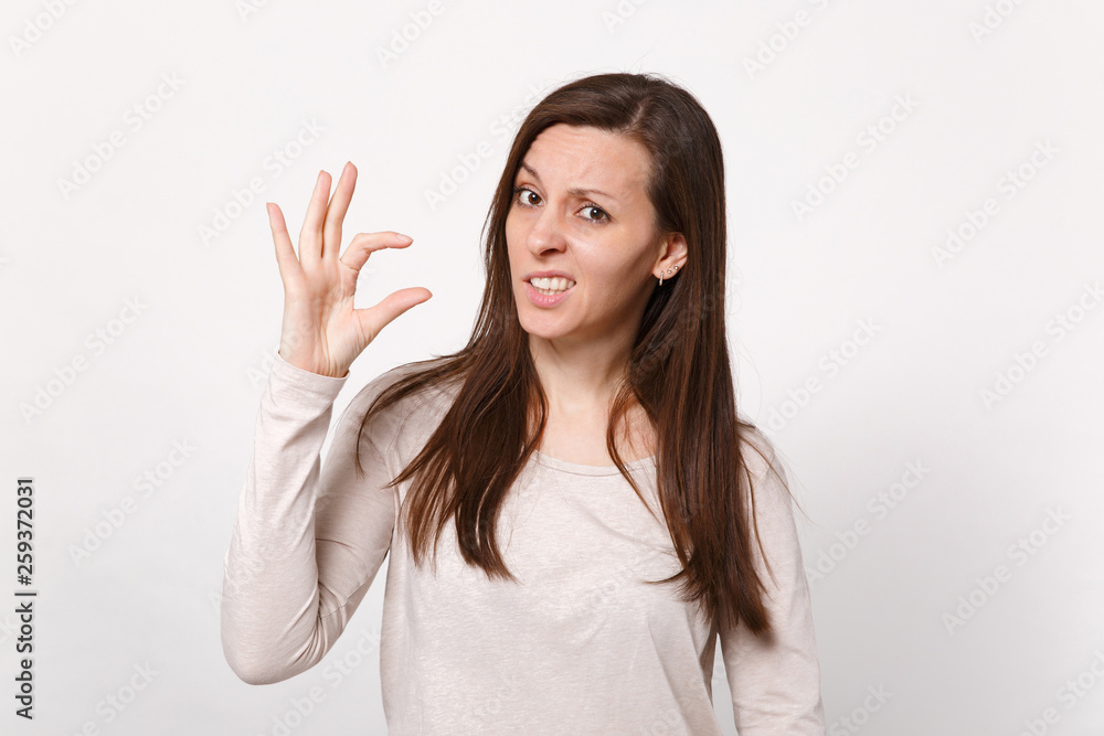 Portrait of puzzled young woman in light clothes gesturing demonstrating size with workspace isolated on white wall background in studio. People sincere emotions lifestyle concept. Mock up copy space. Portrait of puzzled young woman in light clothes gesturing demonstrating size with workspace isolated on white wall background in studio. People sincere emotions lifestyle concept. Mock up copy space.