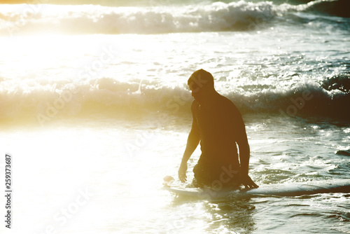 Fototapeta Naklejka Na Ścianę i Meble -  Young man, beginner Surfer learns to surf on a sea foam on the Crete island, beach Falasarna