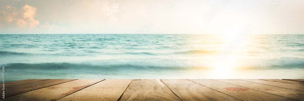 empty wood table on blurred Sea walk on the beach with sunrise, warm tone - obrazy, fototapety, plakaty 