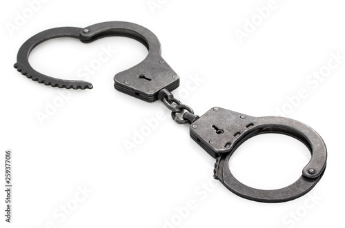 Pair of closed lock steel metal handcuffs isolated on white background.