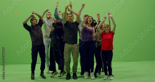 GREEN SCREEN CHROMA KEY Front view group of young people dancing and jumping with hands in the air. 4K UHD ProRes 4444 photo