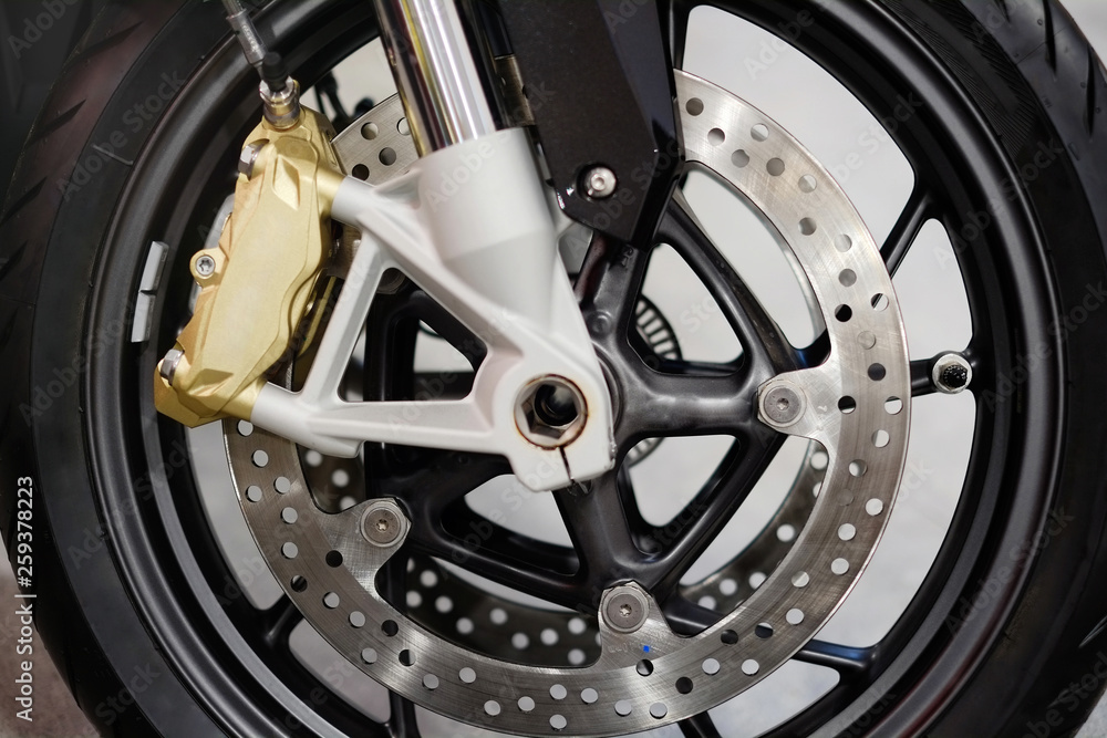 Disc brake with wheel hub on motorbike. Close up of front disc brake on motorcycle. Motorcycle car care and maintenance concepts. - Selective focus