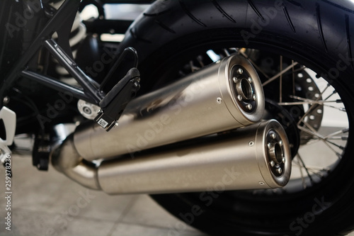 motorcycle rear wheel and dual steel exhaust pipe © lanarusfoto