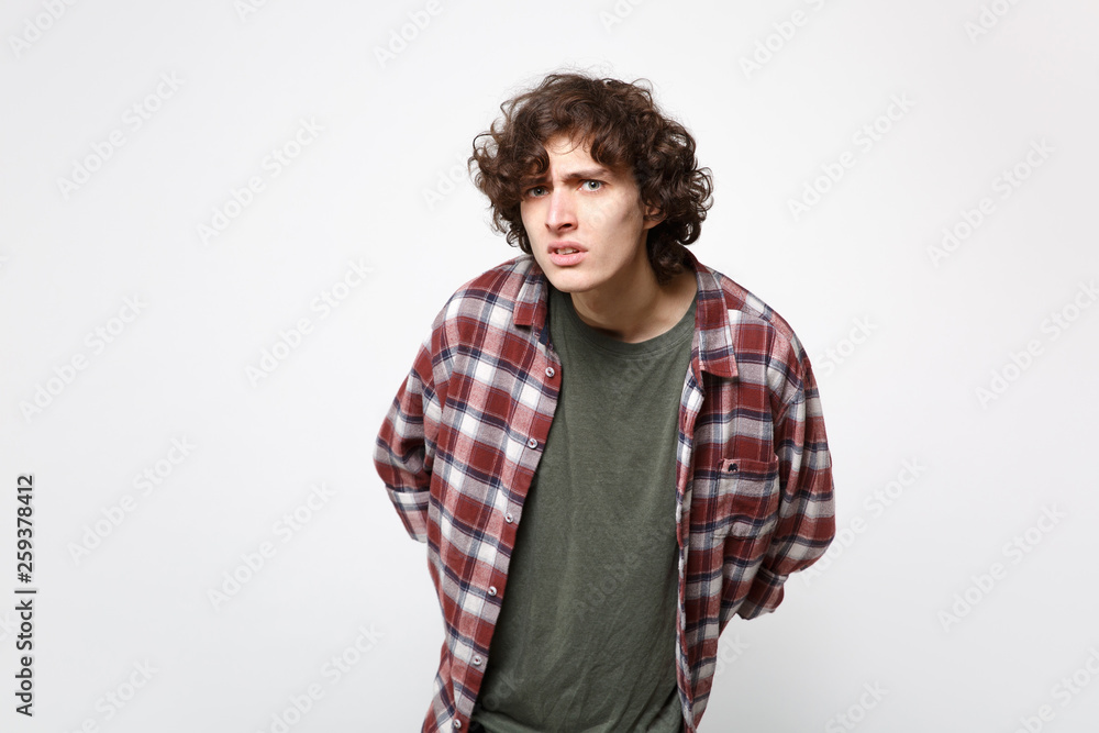 Portrait of perplexed puzzled young man in casual clothes standing and looking camera isolated on white wall background in studio. People sincere emotions, lifestyle concept. Mock up copy space. Portrait of perplexed puzzled young man in casual clothes standing and looking camera isolated on white wall background in studio. People sincere emotions, lifestyle concept. Mock up copy space.