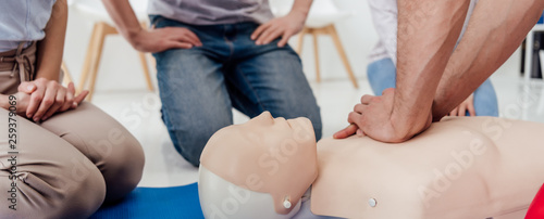 cropped view of man performing chest compression on dummy during cpr training class photo