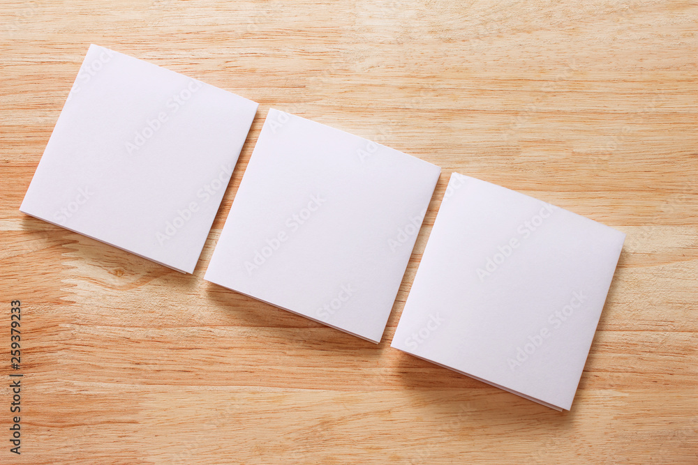 Blank portrait mock-up paper. brochure magazine isolated on brown wooden table, changeable background / white paper isolated on wood Blank portrait mock-up paper. brochure magazine isolated on brown wooden table, changeable background / white paper isolated on wood