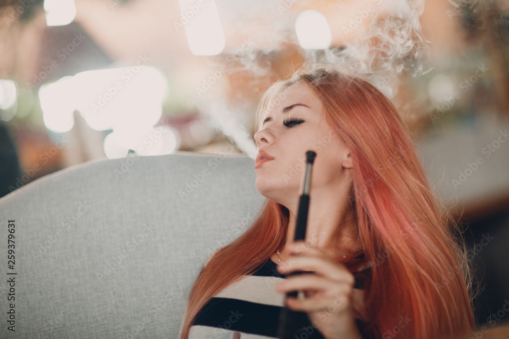 Fototapeta premium Young beautiful female smoking hookah. Smoke shisha hookah concept.