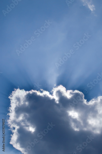 Sun rays from behind cloud. © Tata Chen
