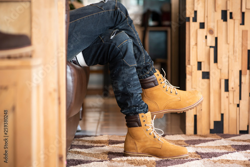 Fashion men’s legs in jeans and yellow boots leather for man collection.