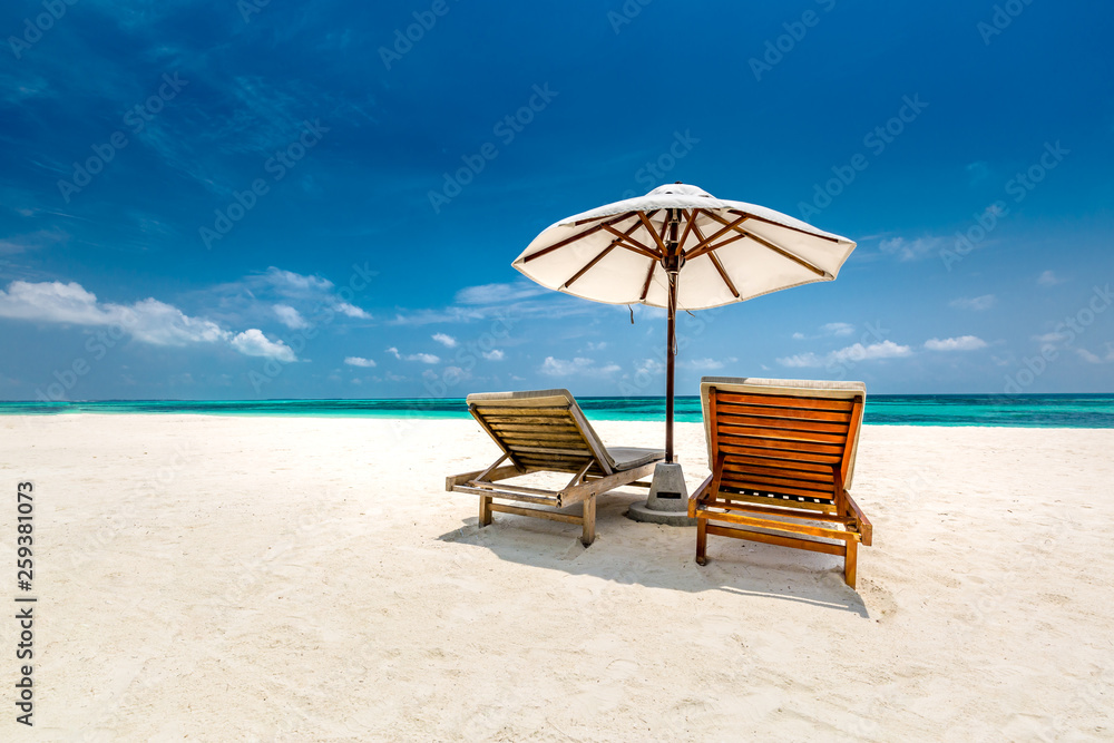 Obraz premium Perfect couple vacation or holiday concept, two sun beds on white sand