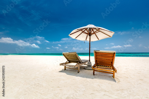 Perfect couple vacation or holiday concept, two sun beds on white sand