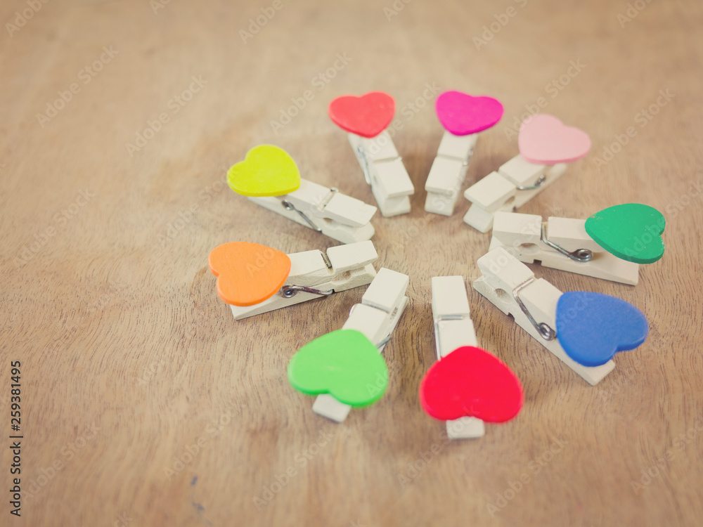 Fototapeta premium Circle consisted of nine wooden clothes-pegs with heart shape. Toned image. Selective focus.