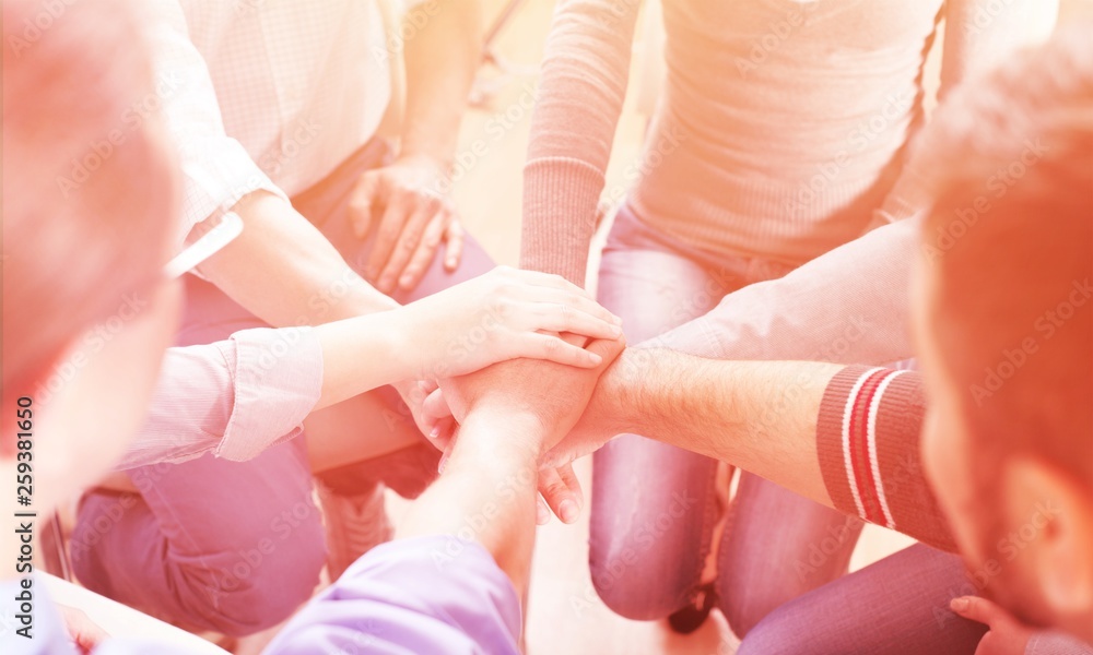 Close-up view of group of people stacking hands Close-up view of group of people stacking hands