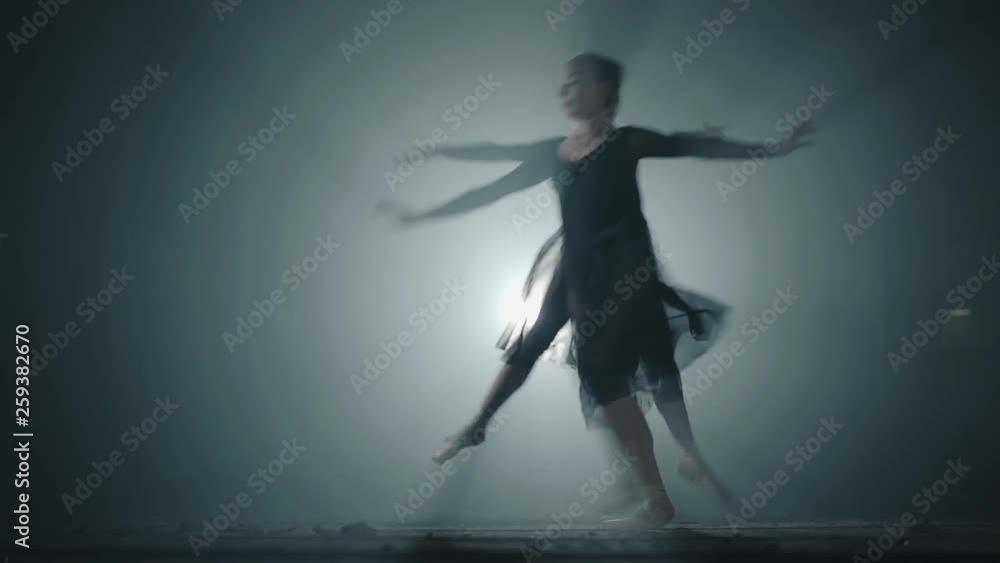 Diligent professional ballerinas dancing in ballet shoes and black dress in the studio in spotlight on a black background. Two young beautiful women ballerina runs up and jumps in different sides Diligent professional ballerinas dancing in ballet shoes and black dress in the studio in spotlight on a black background. Two young beautiful women ballerina runs up and jumps in different sides