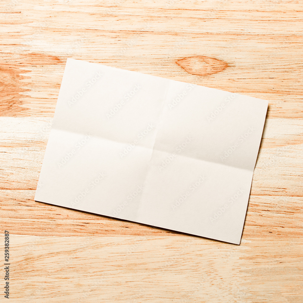 Blank portrait mock-up paper. brochure magazine isolated on brown wooden table, changeable background / white paper isolated on wood Blank portrait mock-up paper. brochure magazine isolated on brown wooden table, changeable background / white paper isolated on wood