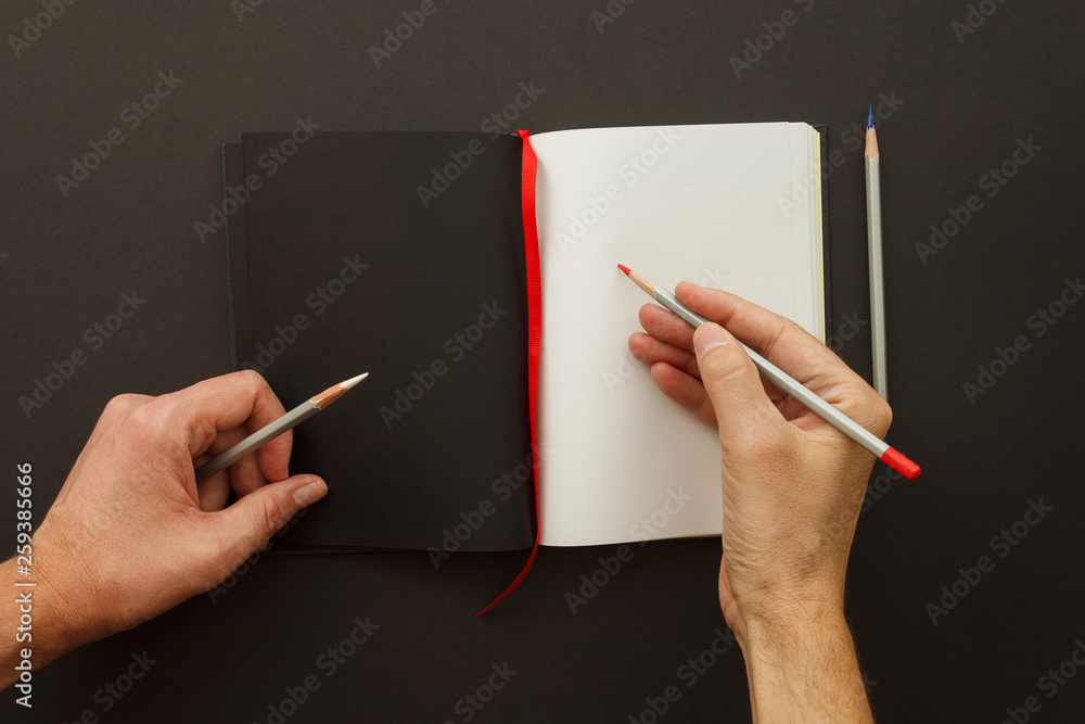 Draw in sketchbook. Artist's hands hold the colored pencils. Clean open  sketchbook and color pencils on a dark background. Hobby and crafts  concept. Top view Stock Photo | Adobe Stock