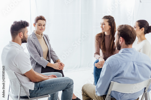 people sitting in circle during support group therapy meeting