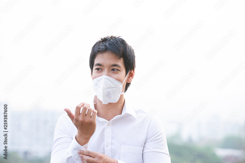Asian man wearing the N95 Respiratory Protection Mask against air pollution at road and traffic in Chiangmai, healthcare concept. Asian man wearing the N95 Respiratory Protection Mask against air pollution at road and traffic in Chiangmai, healthcare concept.