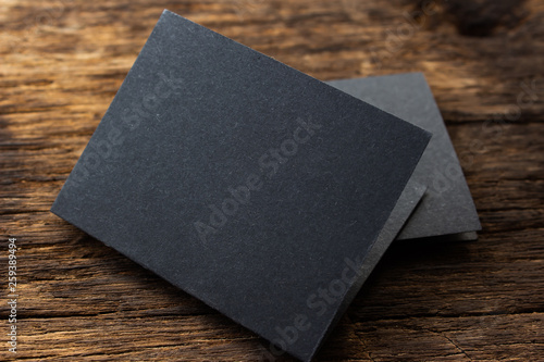 Blank portrait mock-up paper. brochure magazine isolated on brown wooden table, changeable background / Black paper isolated on wood