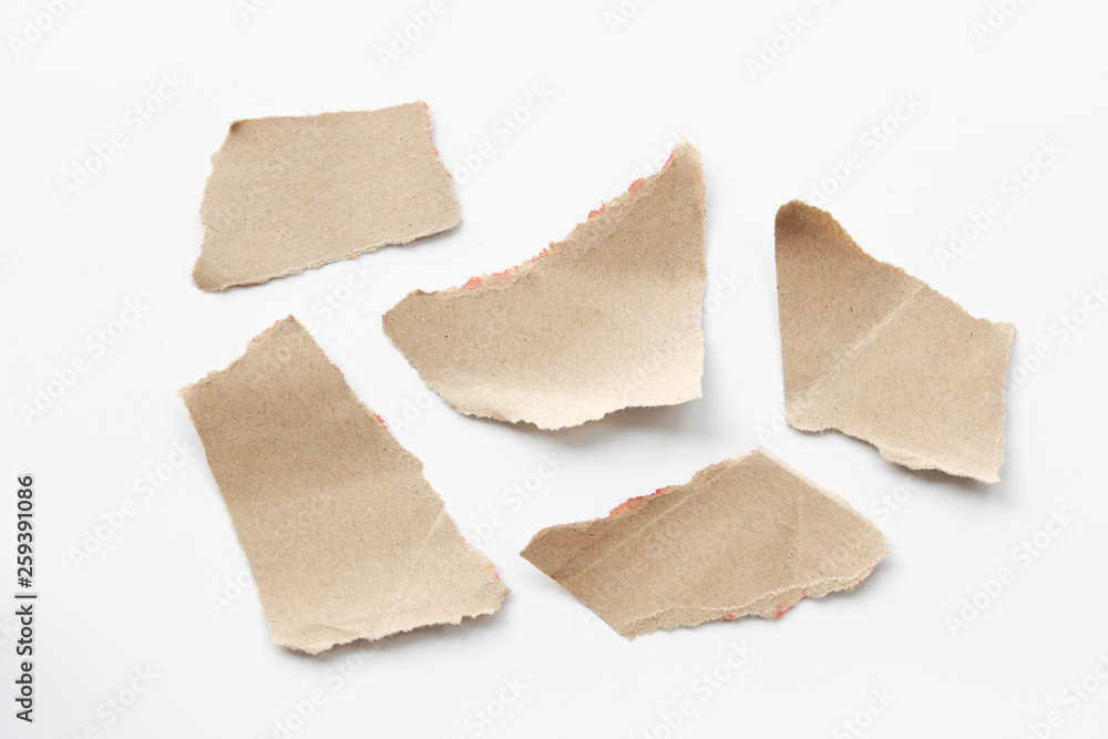 Brown corrugated texture paper torn on white background. rip of cardboard sheet used as a background . Brown corrugated texture paper torn on white background. rip of cardboard sheet used as a background .