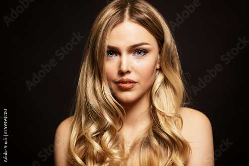 Beautiful young woman  blonde  close-up. Black background.