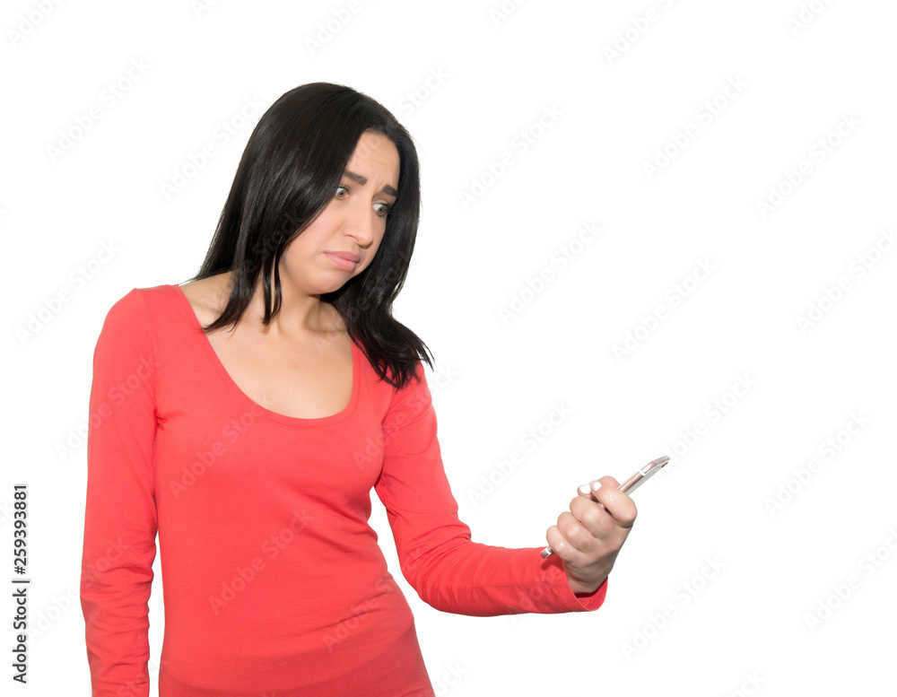 Portrait of a confused casual girl holding mobile phone isolated Portrait of a confused casual girl holding mobile phone isolated