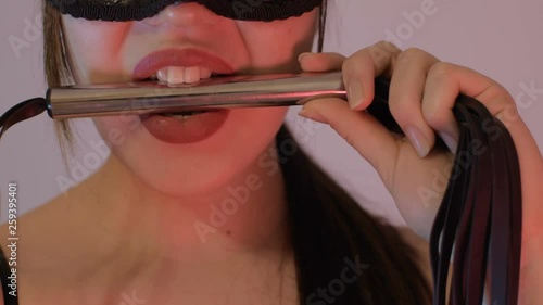 Sexy girl holding whip lips. Red sexy lips. The girl in the mask.