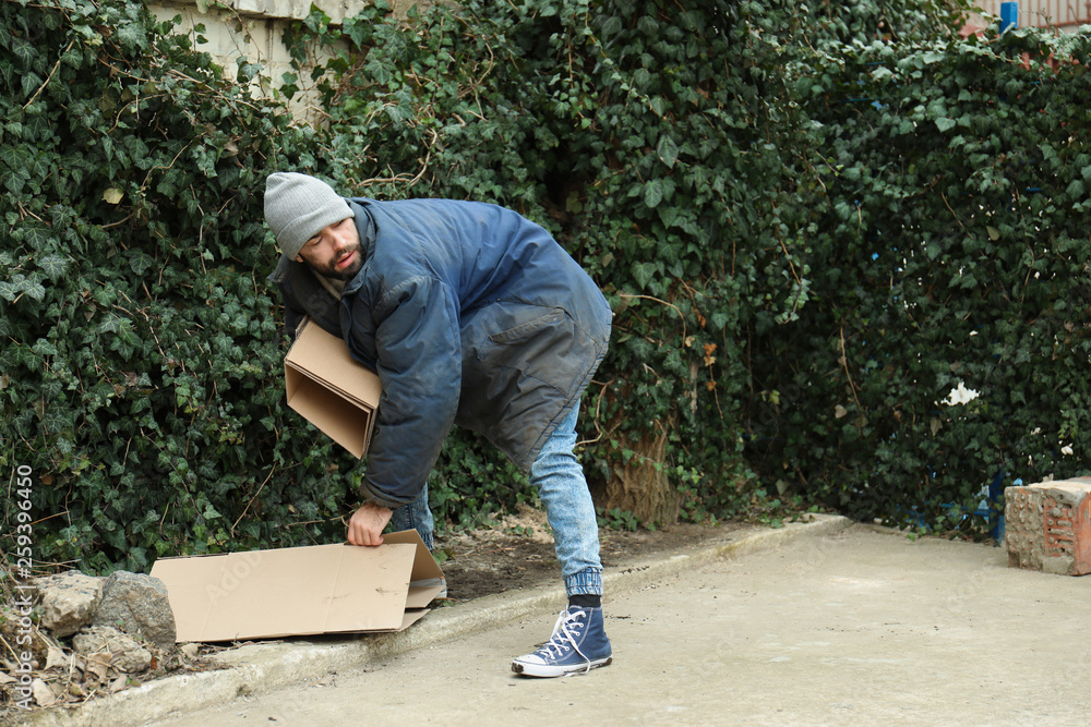 Poor homeless man with cardboard on street Poor homeless man with cardboard on street