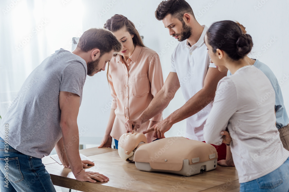 group of concentrated people with cpr dummy during first aid training class group of concentrated people with cpr dummy during first aid training class