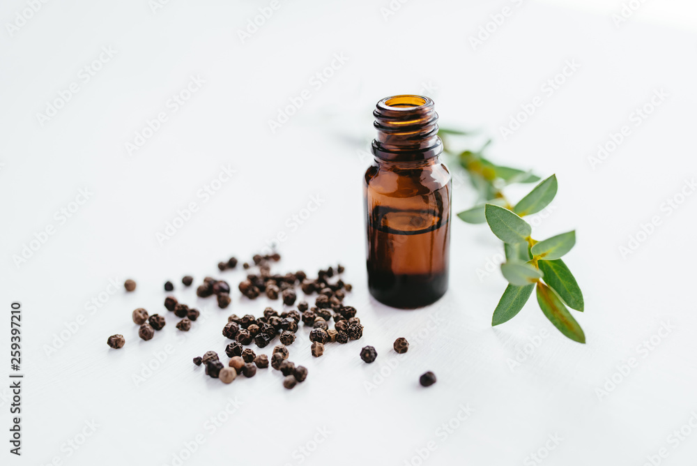 Black pepper essential oil on white background for beauty, skin care, wellness and medicinal purposes. Piper nigrum oil Black pepper essential oil on white background for beauty, skin care, wellness and medicinal purposes. Piper nigrum oil