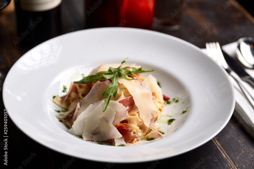pasta with parmesan and prosciutto on a white plate pasta with parmesan and prosciutto on a white plate