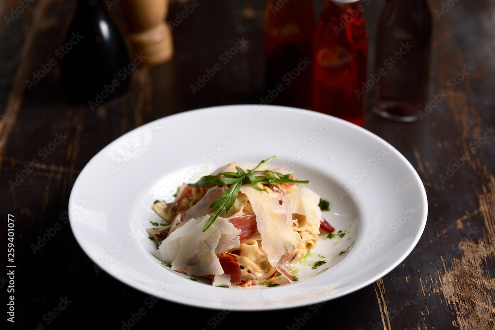pasta with parmesan and prosciutto on a white plate pasta with parmesan and prosciutto on a white plate