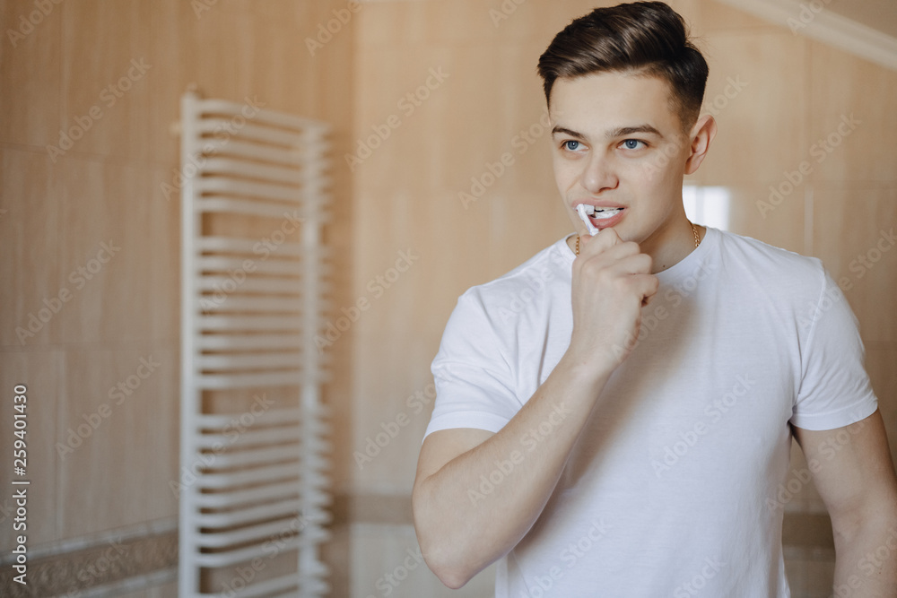 morning hygiene, the boy brushes his teeth near the mirror morning hygiene, the boy brushes his teeth near the mirror