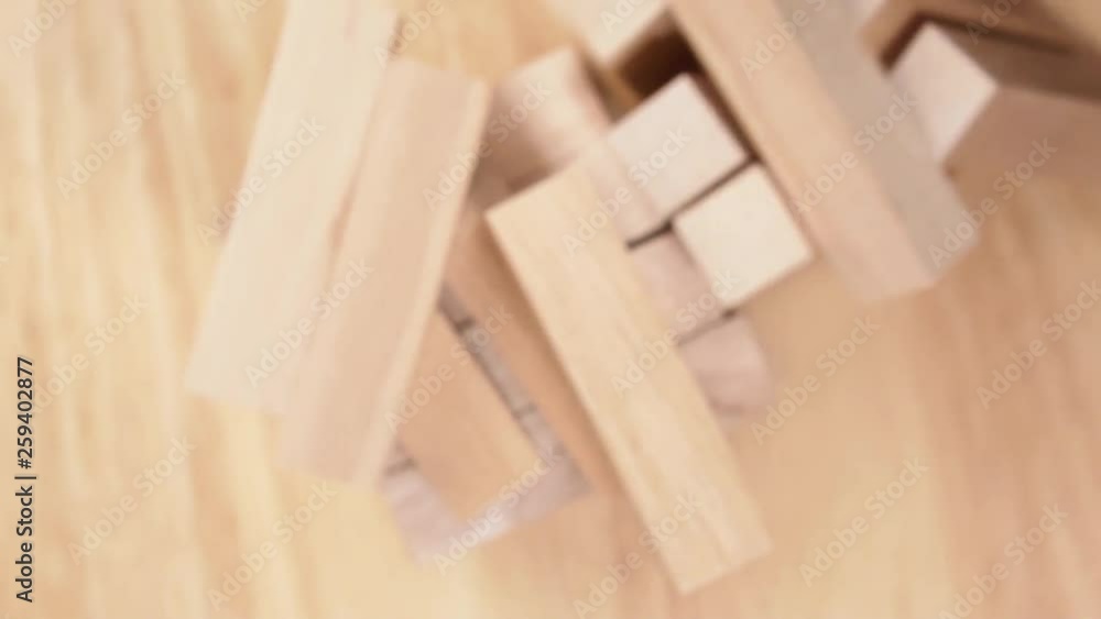 Top view on wooden tower crumbling on the wooden background. The concept of logical thinking. Concept of decay. Top view on wooden tower crumbling on the wooden background. The concept of logical thinking. Concept of decay.