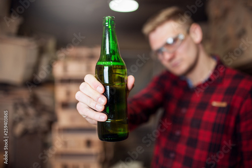 Man in workshop drinking beer after work