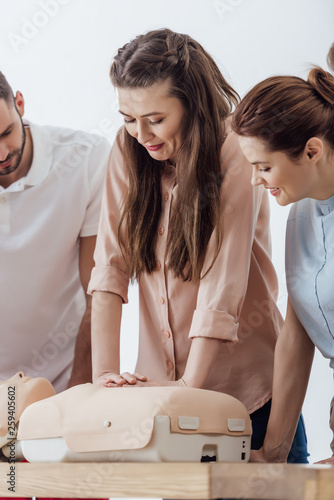 beautiful woman performing chest compression on dummy during cpr training class photo