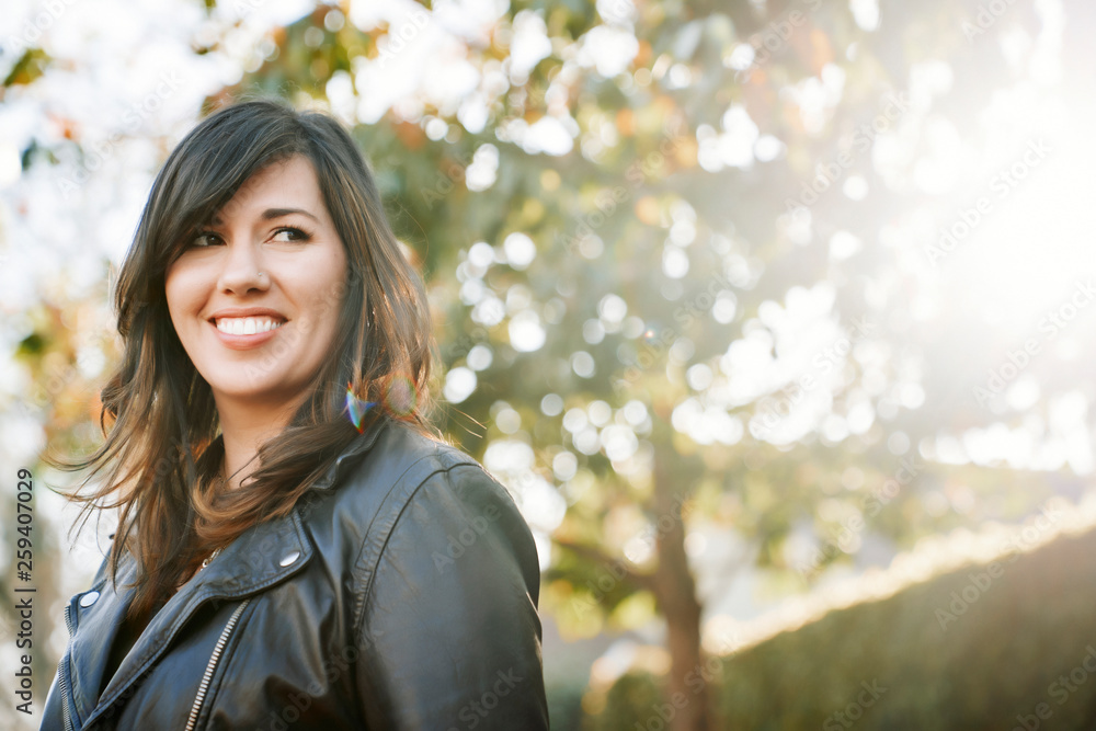 Smiling brunette woman standing outdoors Smiling brunette woman standing outdoors