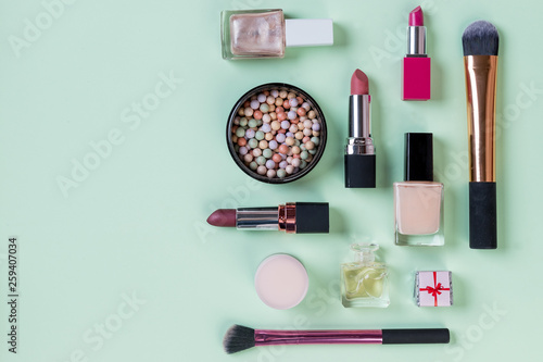 flat lay female cosmetics collage frame with lipstick, brush,powder on pastel green background. top view.Copy space.Professional makeup products with cosmetic beauty products,shopping concept.