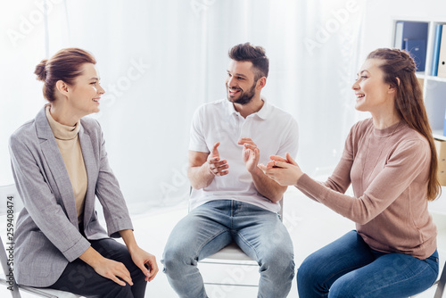 Fototapeta Naklejka Na Ścianę i Meble -  smiling women and man sitting and applauding during group therapy session
