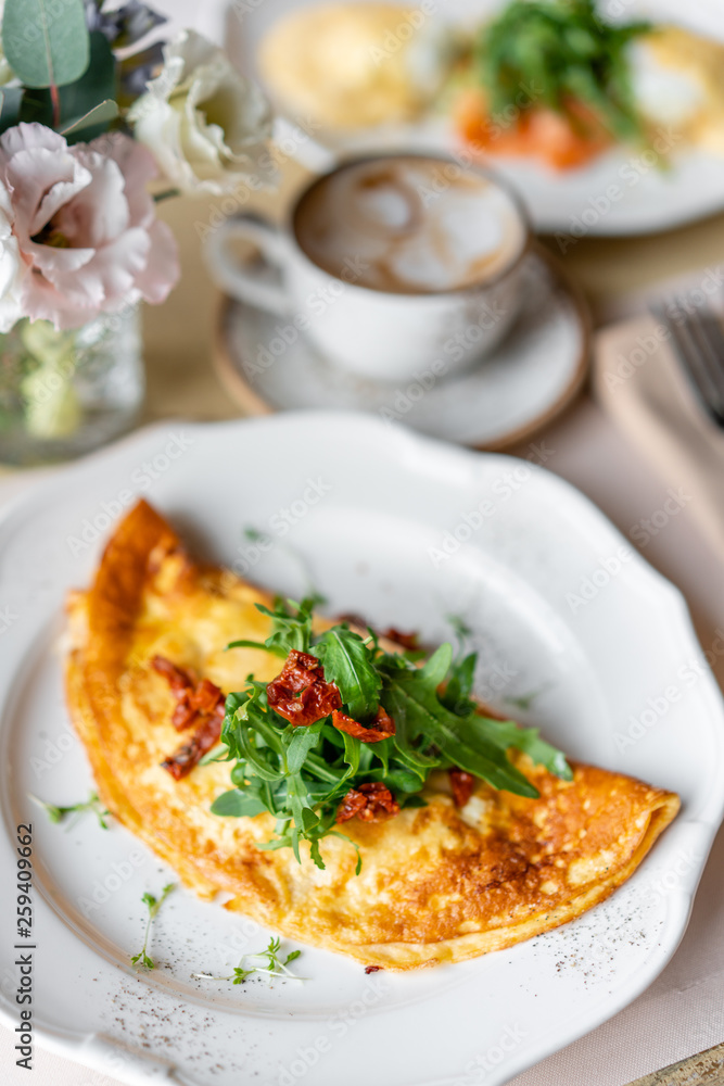 Breakfast. Frittata - italian omelet. Omelette with tomatoes, arugula and soft cheese. Coffee and other dishes on the table in the restaurant Breakfast. Frittata - italian omelet. Omelette with tomatoes, arugula and soft cheese. Coffee and other dishes on the table in the restaurant