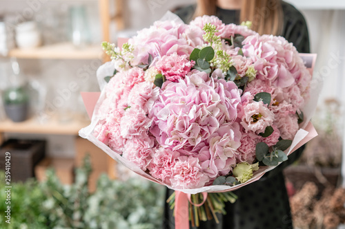 beautiful fresh cut bouquet of mixed flowers in woman hand. the work of the florist at a flower shop. Delicate Pastel tones color