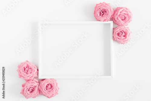 Beautiful flowers composition. Blank frame for text, pink rose flowers on white background. Valentines Day, Easter, Birthday, Happy Women's Day, Mother's day. Flat lay, top view, copy space