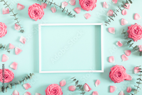 Beautiful flowers composition. Blank frame for text, pink rose flowers, eucalyptus leaves on pastel mint background. Valentines Day, Easter, Birthday, Mother's day. Flat lay, top view, copy space