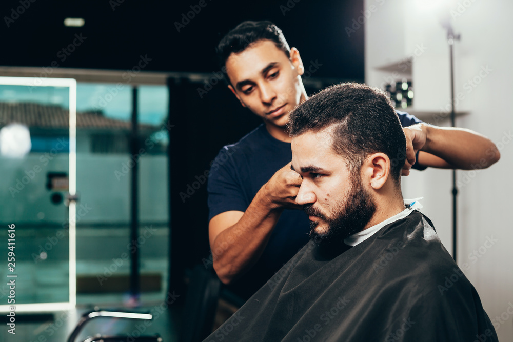 Client during beard and hair grooming in barber shop Client during beard and hair grooming in barber shop