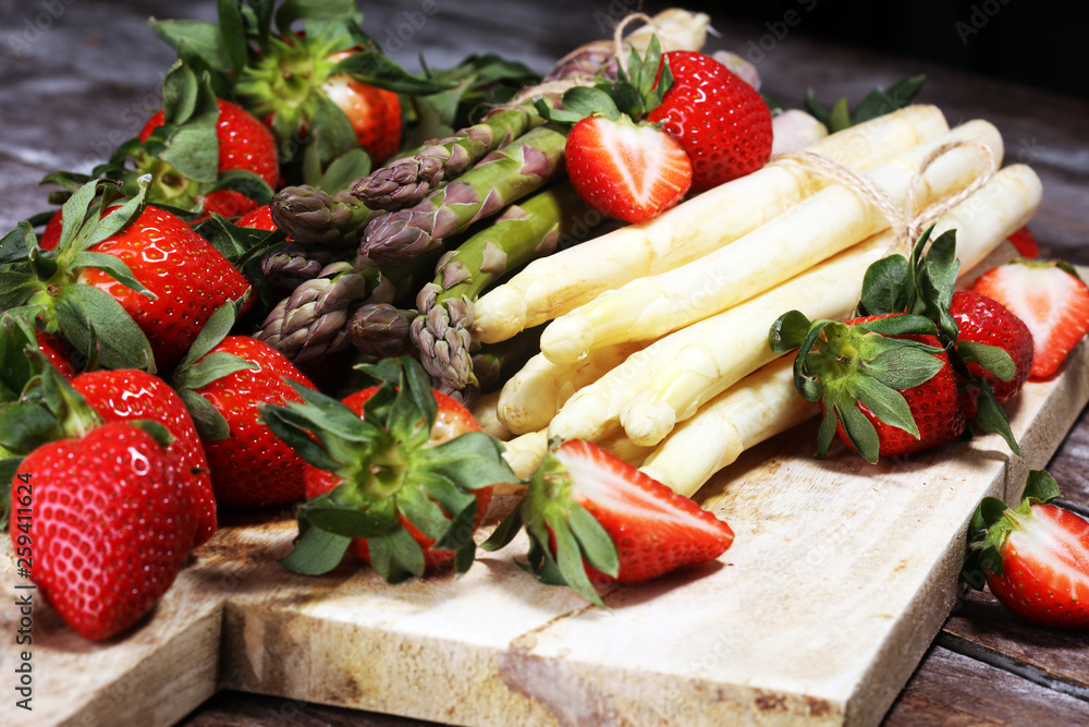 White and green asparagus with strawberries on wood White and green asparagus with strawberries on wood