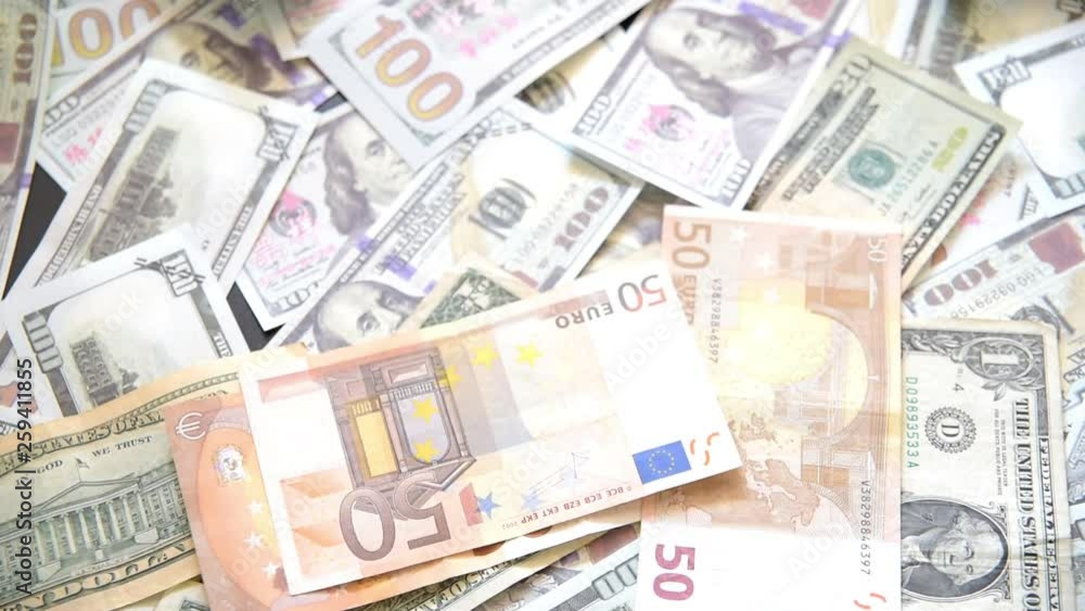 Euro bills falling in front of the camera on a pile of American dollar bills, USA Europe trade war Euro bills falling in front of the camera on a pile of American dollar bills, USA Europe trade war