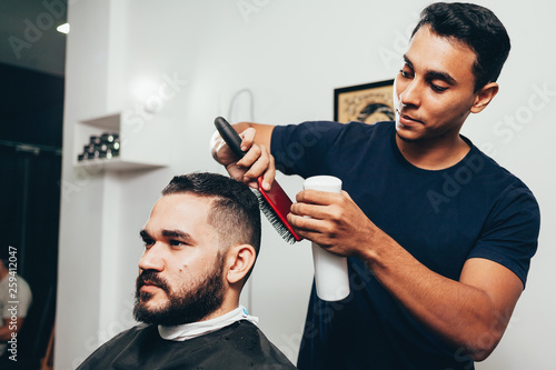 Client during beard and hair grooming in barber shop