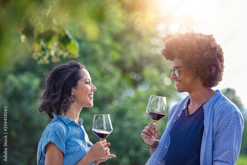 Smiling young couple holding wine glasses outdoors Smiling young couple holding wine glasses outdoors